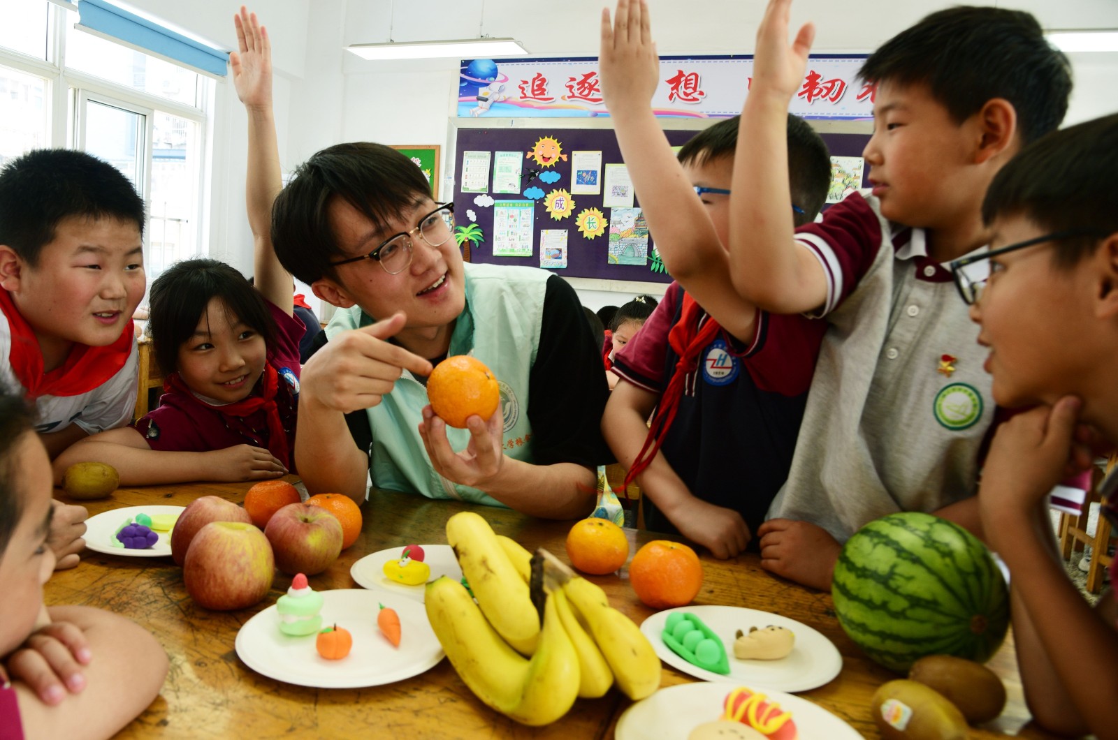 图为志愿者向小学生讲解健康饮食搭配1.jpg