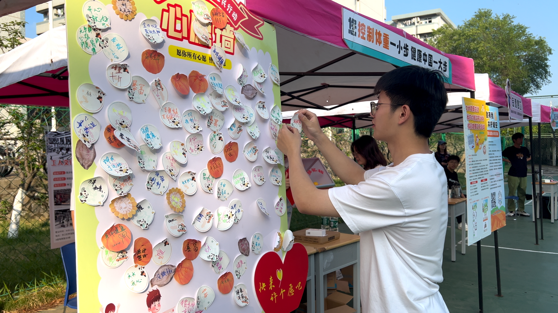 图为同学在心愿墙写下美好寄语.png